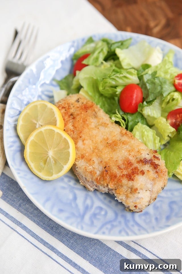 Crispy Parmesan Baked Pork Chops 2 Deliciously crispy Parmesan Baked Pork Chops on a plate