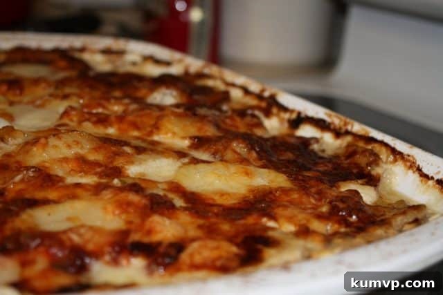 Layers of Flavor: Barefoot Contessa Potato-Fennel Gratin Close-up of creamy Potato-Fennel Gratin, showcasing layers of potatoes, fennel, and melted Gruyère cheese.