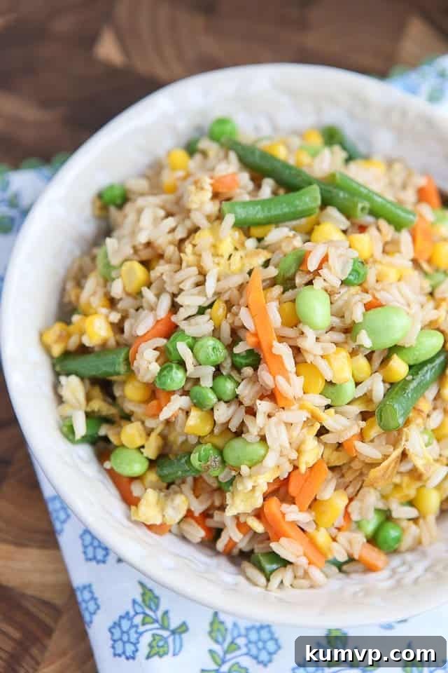 Close-up of freshly made Vegetable Fried Brown Rice, highlighting the texture of brown rice and the colorful assortment of vegetables like edamame, carrots, and peas. A testament to its quick preparation and delicious outcome.