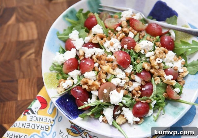 A beautifully composed Wheat Berry and Arugula Salad on a rustic white plate, garnished with fresh herbs and a light vinaigrette.