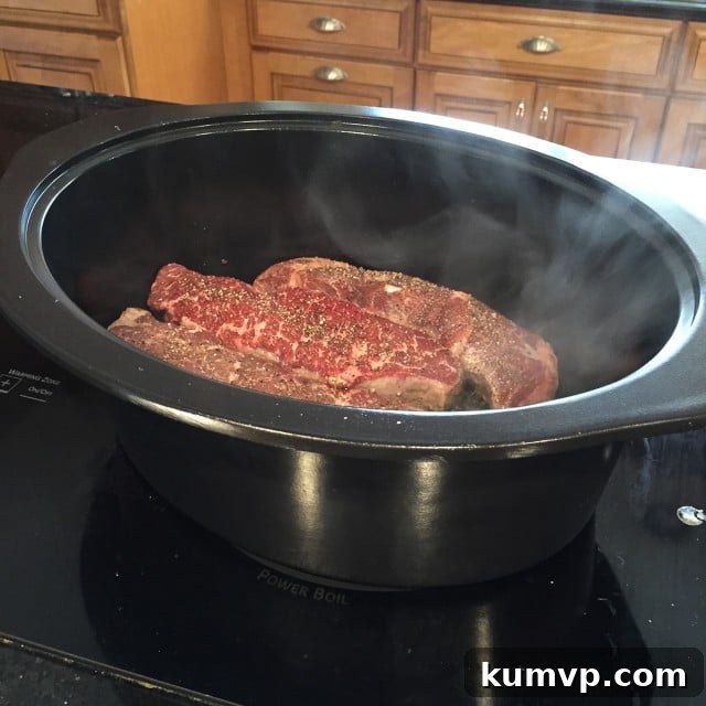 Slow Cooker Barbecue Short Ribs cooking in a Crock-Pot, demonstrating the ease of preparing incredibly flavorful and tender beef with minimal effort.