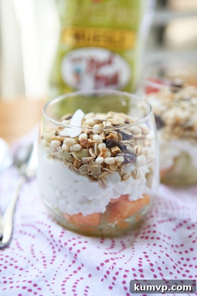 Sunny Melon Power Parfait 2 A vibrant close-up of a Summer Melon Protein Parfait with fresh cantaloupe, honeydew, creamy cottage cheese, and a generous topping of Bob's Red Mill Gluten-Free Muesli, served in a glass jar.