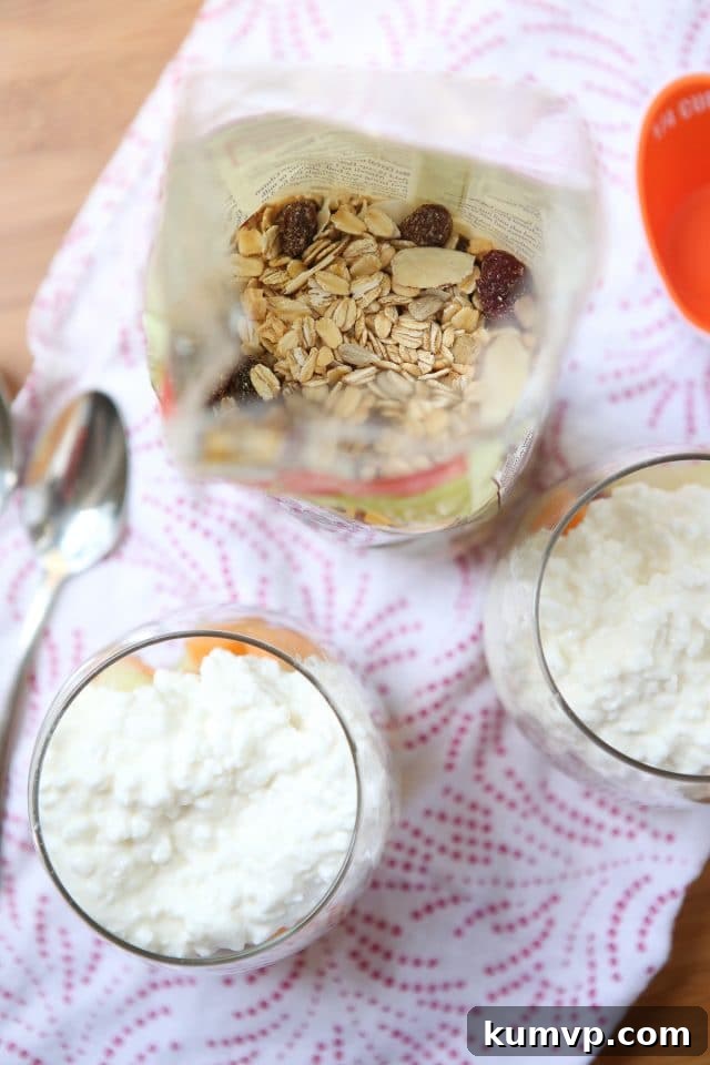 A close-up side view of a Summer Melon Protein Parfait, highlighting the vibrant colors of honeydew and cantaloupe layered with creamy cottage cheese and crunchy Bob's Red Mill muesli.