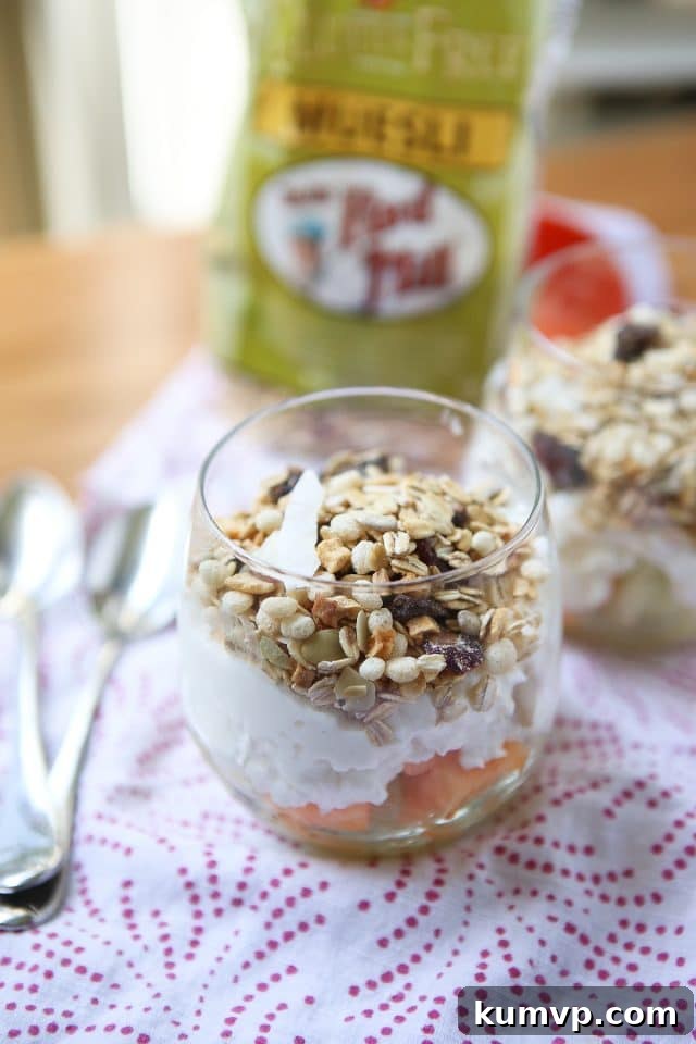 Sunny Melon Power Parfait 6 A vibrant and refreshing Summer Melon Protein Parfait in a glass, with a spoon ready to dive into the layers of melon, cottage cheese, and muesli – a perfect depiction of a healthy summer treat.