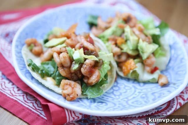 Mango Salsa Shrimp Tacos with Avocado A close-up shot of two perfectly assembled Mango Salsa Shrimp Tacos, garnished with fresh cilantro, ready to be enjoyed.