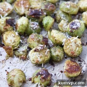 Perfectly roasted Pesto Brussels Sprouts on a baking sheet, with a bowl of fresh pesto. A vibrant and healthy Italian-inspired side dish recipe.