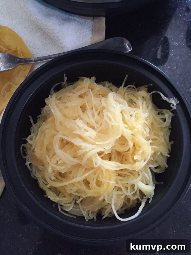 How To Cook Spaghetti Squash in the Instant Pot black meal prep container filled with cooked spaghetti squash