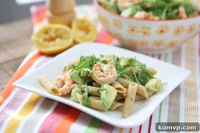plate of whole wheat pasta topped with shrimp, arugula, and diced avocado