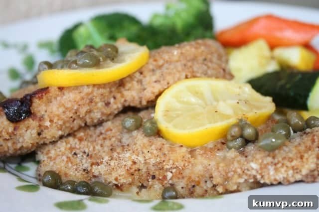 Barefoot Contessa Chicken Piccata with lemon and capers by Ina Garten Golden brown chicken piccata garnished with fresh lemon slices and capers, ready to serve