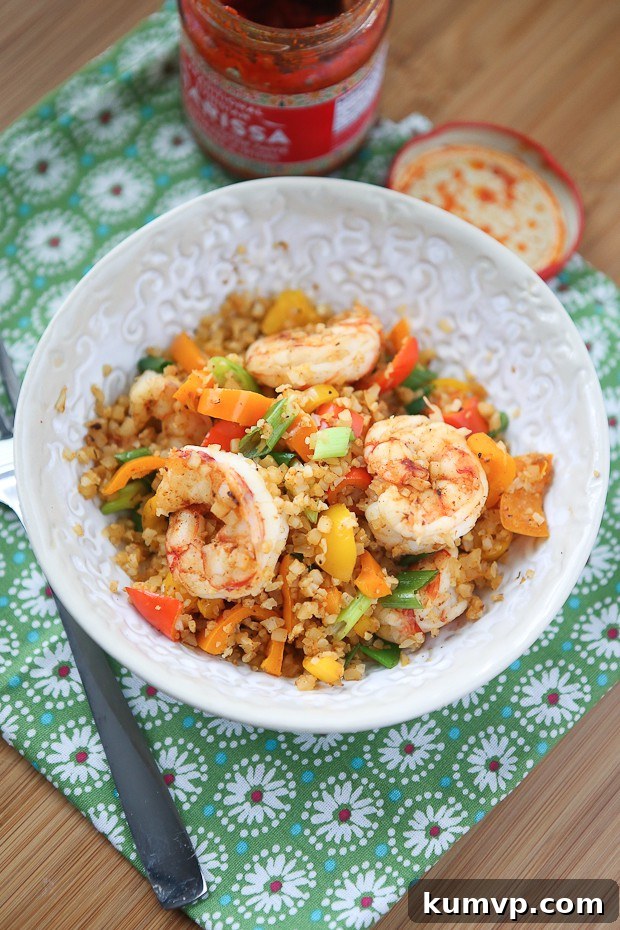 Quick lunch or dinner for one! Cajun Shrimp and Cauliflower Rice Stir Fry - low carb, high protein and full in flavor. A close-up of the flavorful Cajun Shrimp and Cauliflower Rice Stir Fry, emphasizing its appeal as a low-carb, high-protein, and quick meal solution.