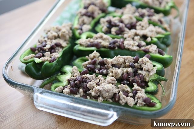 Simple 5 Ingredient Turkey Black Bean Stuffed Poblano Peppers 3 Another enticing view of the Stuffed Poblano Peppers, emphasizing the perfectly cooked turkey and black bean mixture generously topped with bubbling cheese, a testament to its healthy and easy preparation.