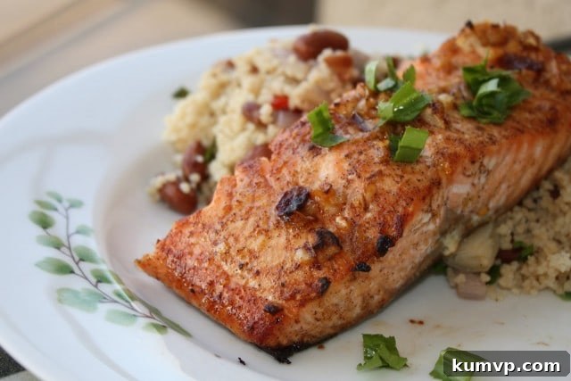 Perfectly broiled Chipotle Salmon fillet garnished with fresh lime and herbs