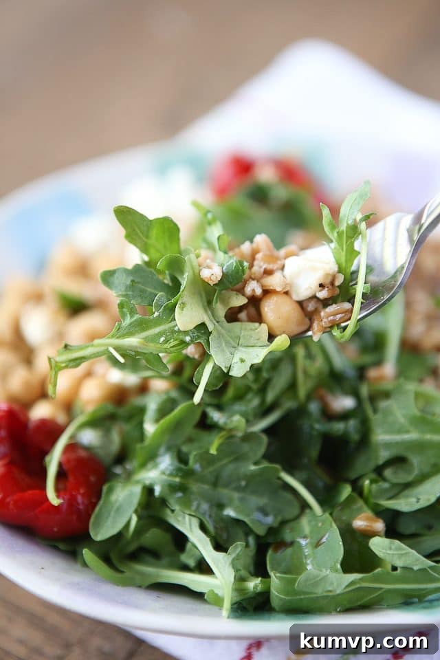 A close-up view of the Mediterranean Farro Salad, highlighting the textures of farro, chickpeas, and fresh arugula. This wholesome dish is packed with fiber and protein, making it an excellent choice for a healthy vegetarian meal. Photo Credit: aggieskitchen.com