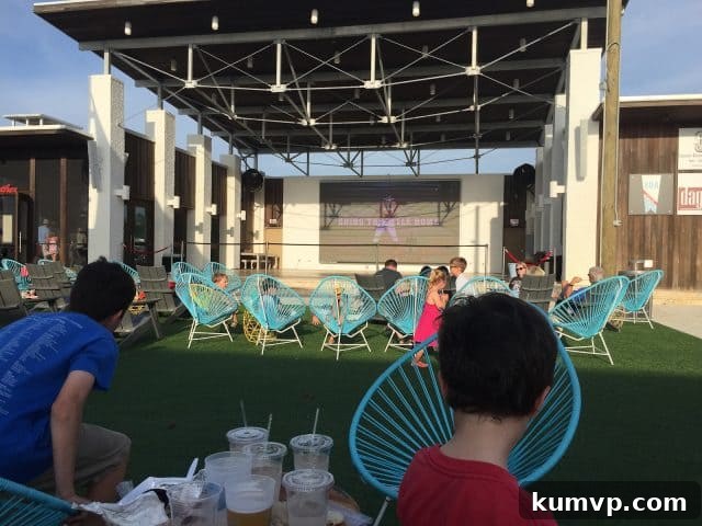 The Hub on 30A: Outdoor Entertainment and Dining The bustling open-air plaza of The Hub on 30A, with various food trucks and seating areas, all centered around a large outdoor screen.