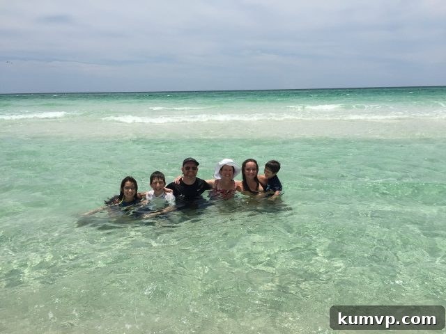 Joyful Family Moment on Blue Mountain Beach A happy family captured mid-jump on the pristine white sands of Blue Mountain Beach, against the backdrop of the clear Gulf waters, symbolizing joy and freedom.