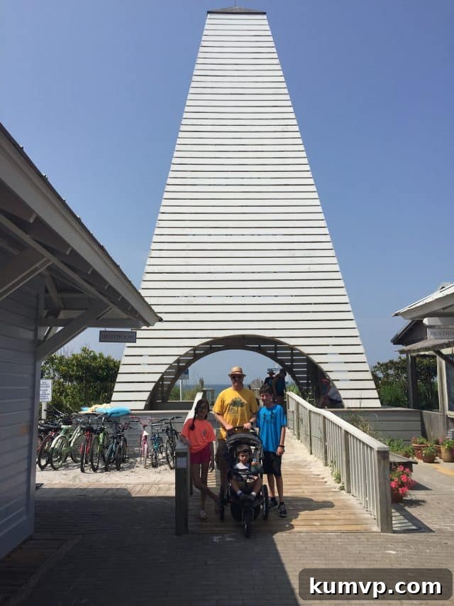 Seaside's Iconic White Picket Fences and Coastal Homes A serene street scene in Seaside, Florida, featuring iconic white picket fences, lush green lawns, and classic coastal architecture under a clear sky.