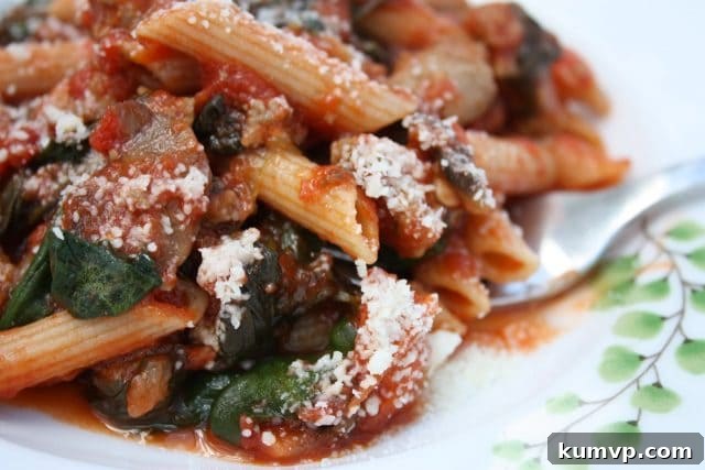 Robust Sausage Penne with Fresh Spinach and Tangy Tomatoes 3 Ingredients for Penne with Sausage, Spinach, and Tomatoes, including whole wheat penne, fresh spinach, turkey sausage, and crushed tomatoes, laid out on a kitchen counter.