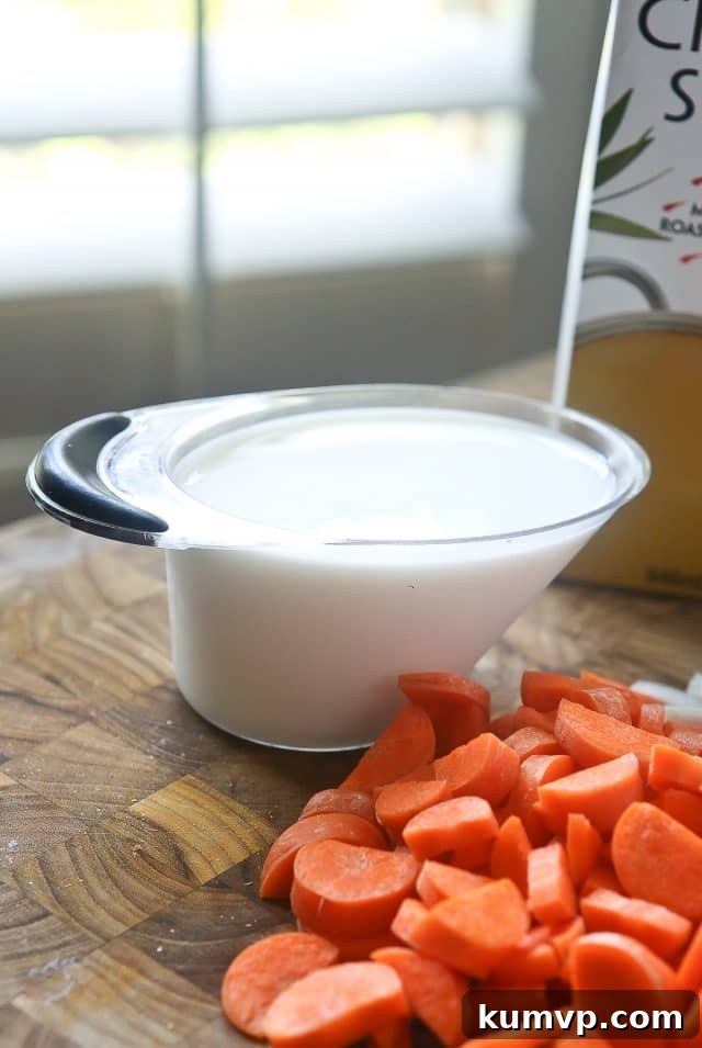 A close-up of a rich and creamy Slow Cooker Chicken and Wild Rice Soup, garnished with fresh herbs. This comforting soup is made with nutritious ingredients, including milk, chicken, vegetables, and wild rice, making it perfect for a healthy family dinner. #ad #UndeniablyDairy @DairyGood