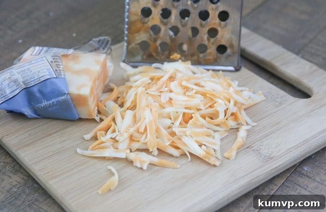 A steaming bowl of Slow Cooker Creamy Chicken and Wild Rice Soup, generously topped with shredded cheese. This hearty and delicious soup is a perfect quick and healthy dinner option for busy families during the school week. #ad #UndeniablyDairy @DairyGood