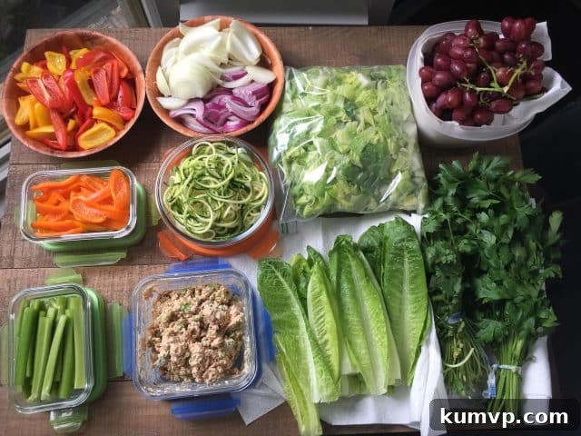 A collection of clear glass containers filled with various prepped vegetables and fruits.