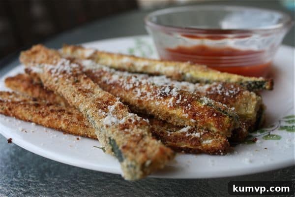 Golden brown crispy Oven Baked Parmesan Zucchini Sticks Close-up of golden brown oven-baked Parmesan zucchini sticks arranged on a baking sheet, ready to serve.