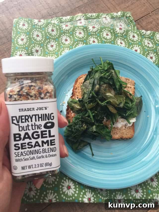 Simple & Quick: Spinach and Egg Toast Prep Close-up shot of a Spinach and Egg Breakfast Toast, emphasizing the rich texture of the cooked spinach and the perfectly set egg white with a hint of a soft yolk, all resting on a piece of toasted whole-grain bread.