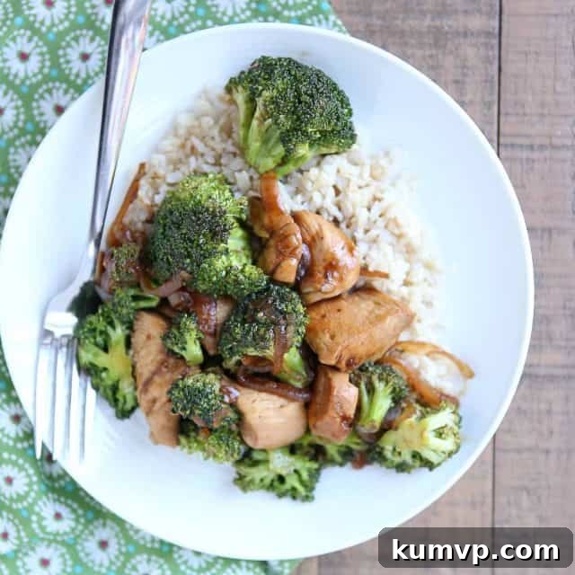 white plate with chicken and broccoli stir fry over brown rice