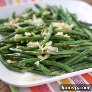 Beautifully plated Roasted Green Beans with Almonds, garnished with fresh lemon zest, ready to be served as a delightful side.