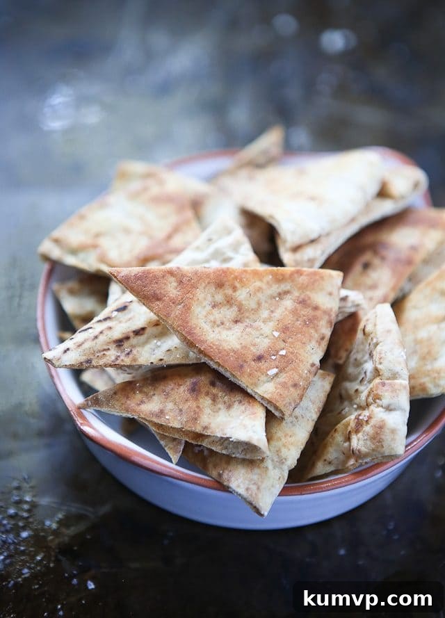 Crispy homemade baked pita chips arranged on a plate, ready to be served with your favorite dips. These chips are a healthy alternative to store-bought options and perfect for pairing with hummus or salsa.