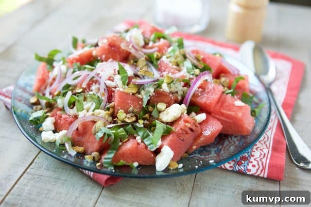 Close-up of Watermelon Feta Salad, showcasing the bright red watermelon, white feta, and green basil leaves against a white bowl.