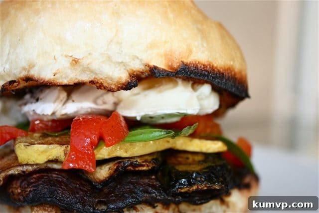 Two gourmet Grilled Portabella and Brie Burgers presented on a wooden board, garnished with fresh basil, ready for a delightful meal.