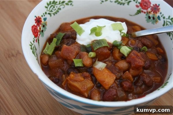 Hearty and delicious 3-Bean Pumpkin Chili in a ceramic bowl, ready to be served and enjoyed after a clean eating week. A small chip is visible on the bowl's rim, adding character.