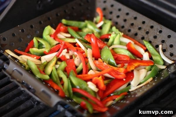 Sizzling Grilled Fajita Vegetables Colorful bell peppers and onions sizzling in a grill basket on a hot grill