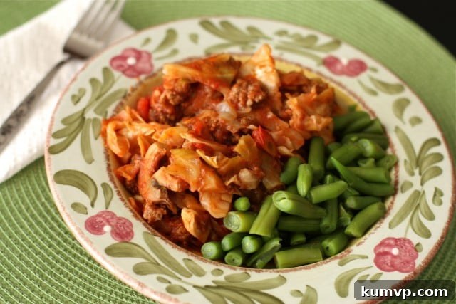 Stuffed Cabbage Casserole A hearty plate of Stuffed Cabbage Casserole featuring ground turkey in a rich red tomato sauce, accompanied by a side of fresh green beans. This low-carb, healthy casserole is a perfect comfort food.