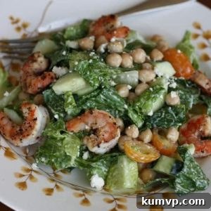 Close-up of a finished Mediterranean Caesar Salad with Lemon Pepper Shrimp and Garbanzo Beans.