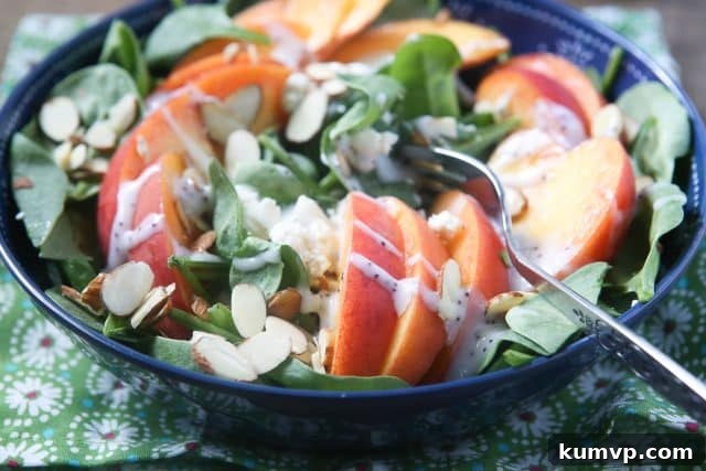 Close-up of a refreshing Peach and Spinach Salad featuring crumbled Gorgonzola Cheese