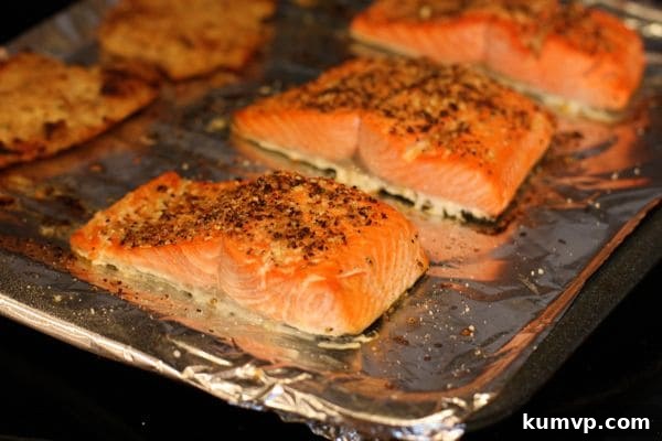 salmon covered in seasonings on a baking sheet covered with aluminum foil