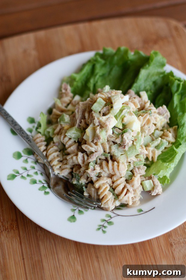 Protein-Packed Tuna Pasta Salad with Greek Yogurt A portion of tuna pasta salad served in a bowl with fresh lettuce, featuring visible chunks of tuna, hard-boiled egg, and crisp celery pieces, highlighting its hearty and healthy appeal.