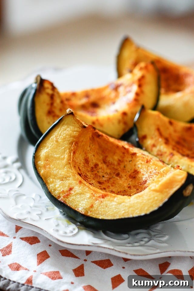 Enjoy this seasonal Roasted Acorn Squash seasoned well with smoked paprika. Looks great on a plate and is good for you! A perfectly roasted acorn squash wedge with crispy edges on a white plate, garnished with fresh herbs, ready to be enjoyed.