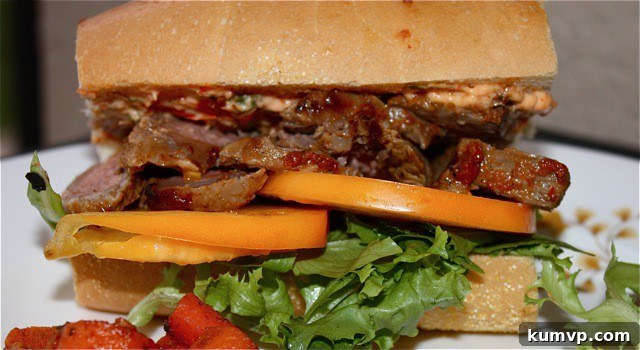 Harissa Steak Sandwich Details Close-up of Harissa Steak Sandwich, showing layers of steak, harissa mayo, and tomatoes