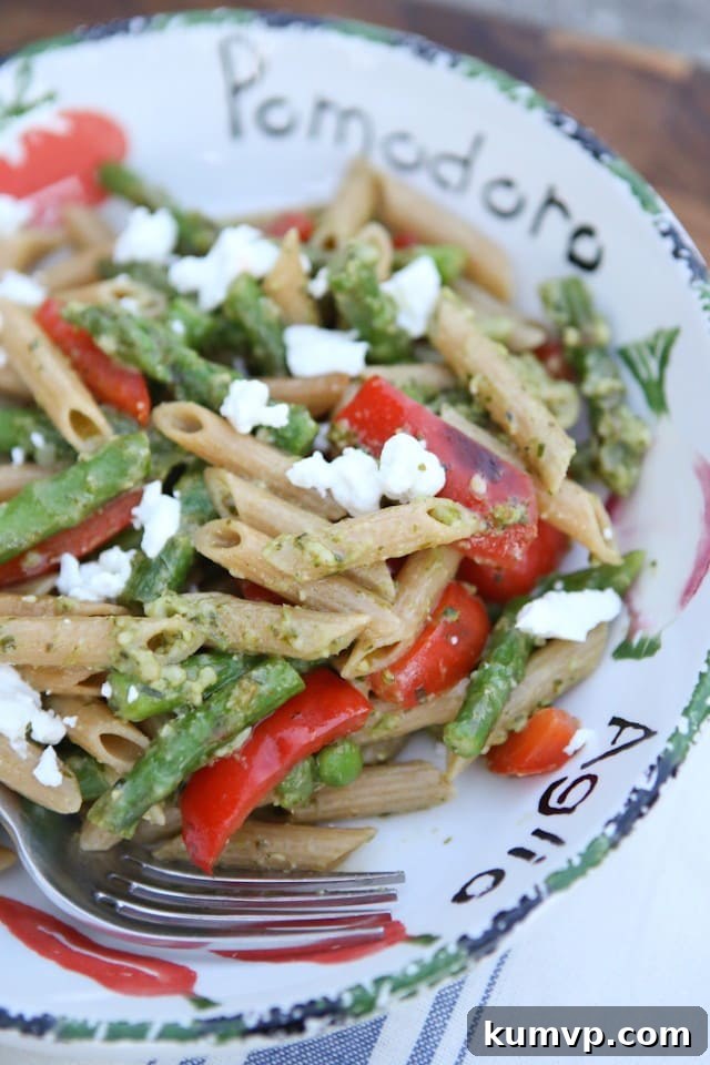 A vertical shot of the Spring Vegetable Pasta with Pesto, highlighting the generous serving size and delicious combination of fresh ingredients.